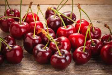 Cherries on wooden rural table with water drops macro background