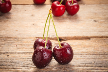 Cherries on wooden rural table with water drops macro background