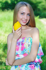 Healthy lifestyle concept with attractive happy woman holding a lemon close to her face