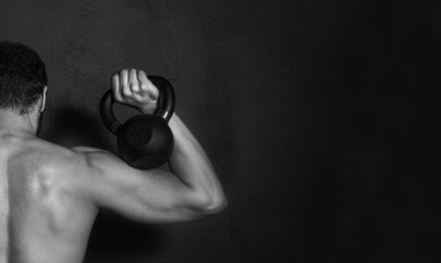 Bodybuilding. Strong young man doing exercise with dumbbell on black background - 85243082