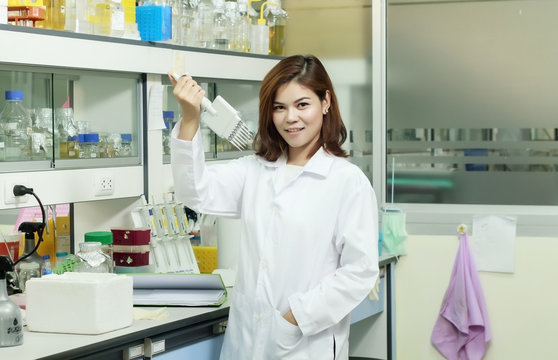 Young female tech or women asia scientist working with multichannel pipette in biological laboratory