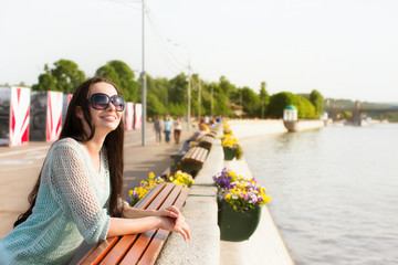 Young beautiful woman in sunglasses in a city park