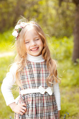 Laughing baby girl 4-5 year old outdoors. Smiling child having fun in park. Posing. Childhood.