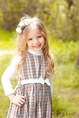 Smiling baby girl posing in park outdoors. Looking at camera. Childhood. 