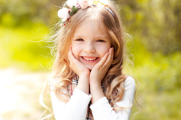 Closeup portrait of cute smiling kid girl 3-4 year old outdoors. Summer time. Freshness. 