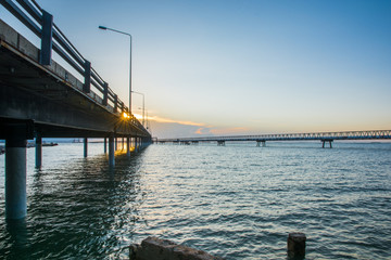 Obraz premium Concrete Bridge over sea water with sunrise
