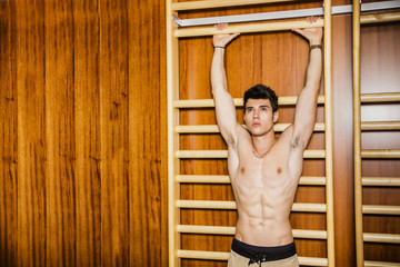 Young man hanging from gym equipment