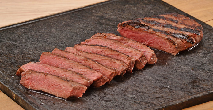 Carne de ternera rebanada sobre piedra caliente.