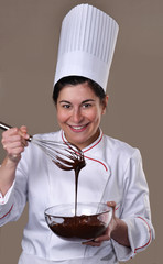 Cocinera cocinando probando crema de chocolate.