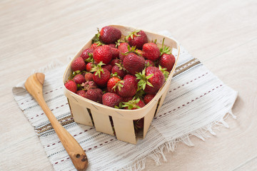Basket with strawberries and wooden spoon