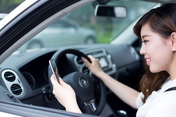 Fototapeta na wymiar asian beautiful woman using mobile phone and driving car