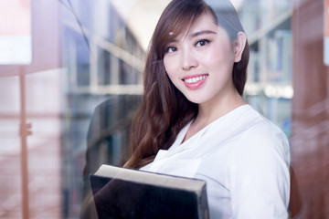 asian beautiful female student holding book in library portrait