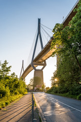 The Köhlbrand Bridge in the Port of Hamburg is illuminated from below at sunset. Opened in 1974, it is an important cable-stayed bridge and a landmark in the harbour.  © ksl