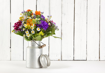 Nostalgic summer flower bouquet arranged in old milk churn