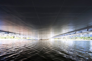 flowing river below bridge of modern city
