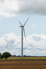Fototapeta premium Wind turbine in the field and stormy sky