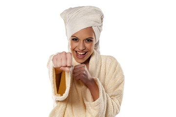 smiling woman in bathrobe and towel on her head showing his fist