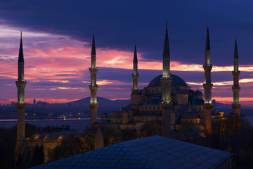 Naklejka na ściany i meble Sultan Ahmed Mosque at sunrise most famous Ottoman Cathedral in Istanbul city illuminated with night spotlight and amazing sunrise sky on background