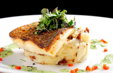 Tasty healthy fish fillet with potato puree with dried tomatoes and wild garlic sauce