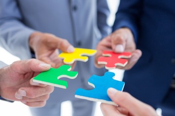Business colleagues holding piece of puzzle