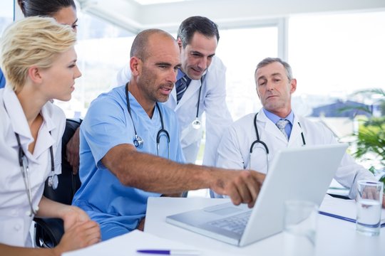 Doctor showing laptop pc to his colleagues 