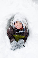 boy playing in a snow fort