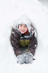 boy playing in a snow fort