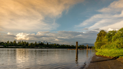 Sunset over the Fraser River near Fort Langley with the Golden Ears mountain in the background - obrazy, fototapety, plakaty