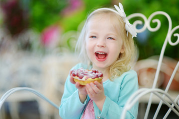 Adorable little girl eating fresh strawberry cake