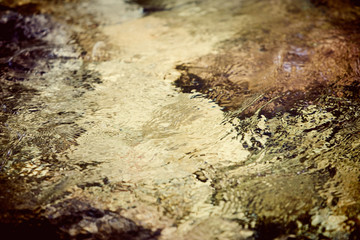 Clear and cool watery background. Mountain river with rocky bottom. 