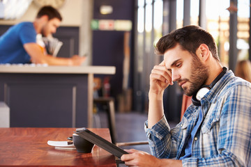 Man using digital tablet in a coffee shop