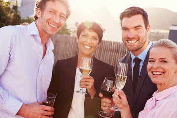 Colleagues drinking after work at a rooftop bar