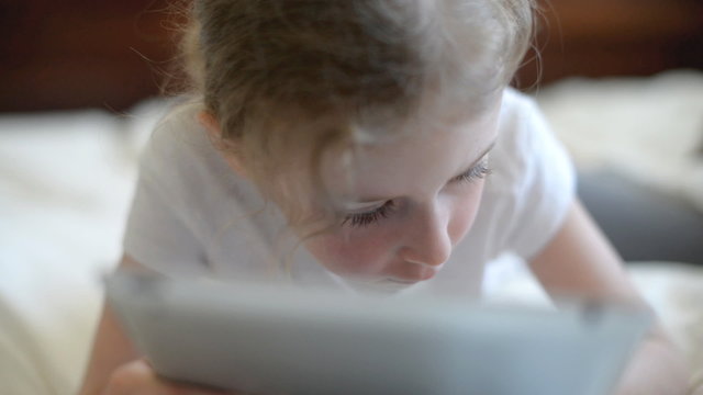 Little girl playing on the tablet pc.
