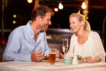 Couple eating dinner at rooftop restuarant