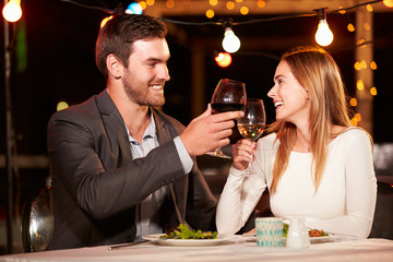 Couple eating dinner at rooftop restuarant