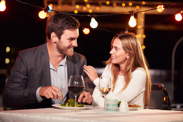 Couple eating dinner at rooftop restuarant