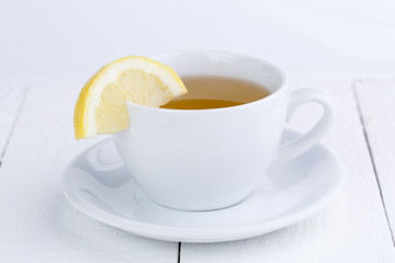 Green tea with lemon on wooden table.