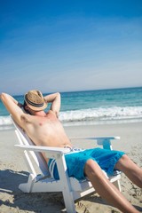 Man relaxing on deck chair at the beach