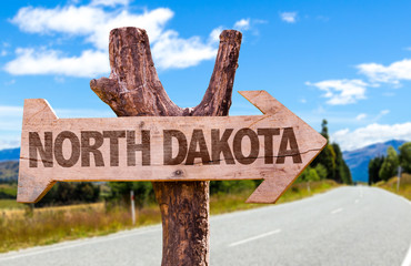 North Dakota wooden sign with road background