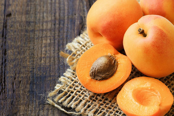 Fresh ripe apricots on a rustic wooden table - obrazy, fototapety, plakaty