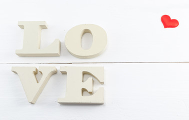 Wooden letters forming word love written on white wooden background