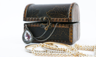 Vintage oval pendant in wooden jewelry box and beautiful golden bracelets on white background