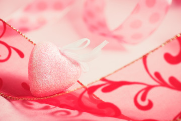 Valentine's Day heart and decorative ribbon on pink background. 