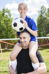 teenager girl with father play soccer