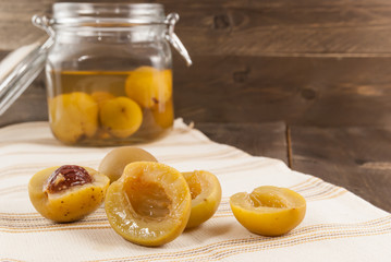 Sliced apricots from compote on wooden background
