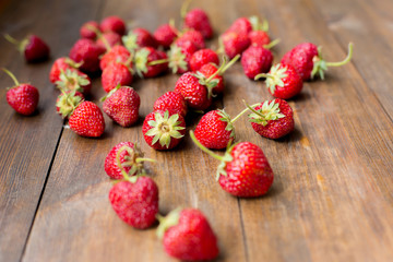 organic fresh sweet strawberries as a seasonal breakfast in the morning right from farmers market on dark wood table background decorated in rustic style

