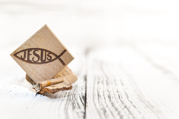 Christian fish symbol carved in wood on white vintage wooden background, Shallow depth of field