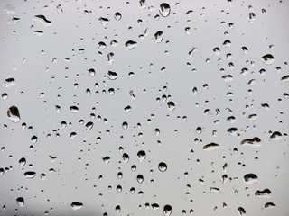 Rain drops on window glass with reflection inside