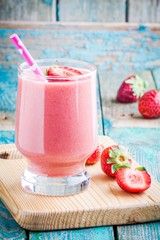 strawberry smoothie in a glass with a straw