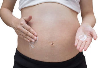 Pregnant woman applying cream on her belly, isolated against whi